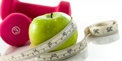 apple, dumbbells and measuring tape